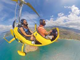 Open-cockpit gyroplane over Oahu's North Shore coastline at 1,000 feet
